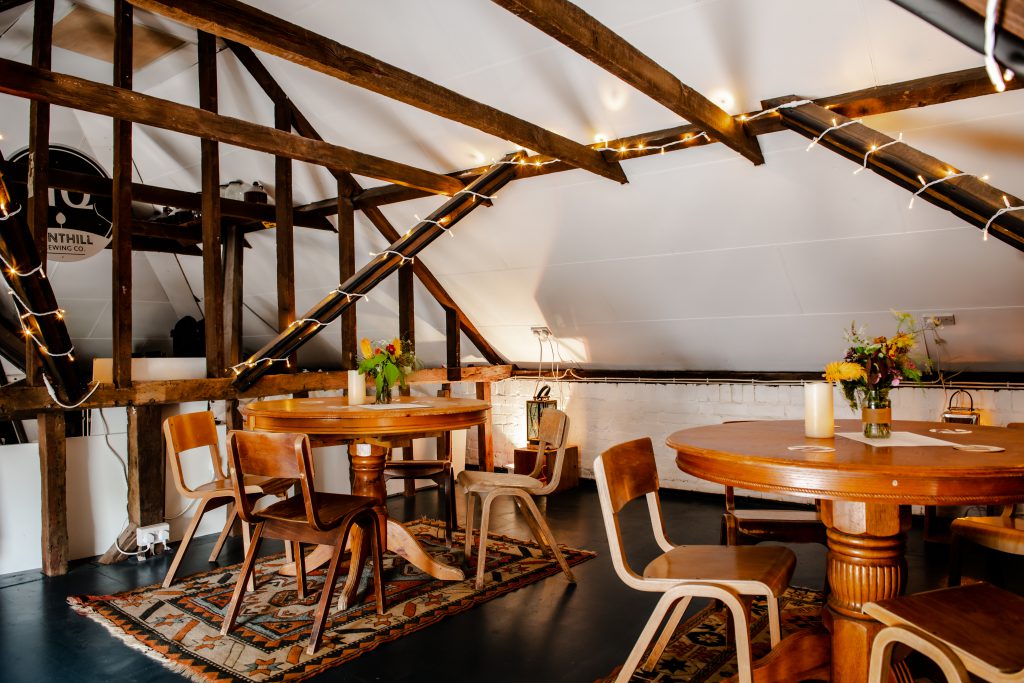 Upstriars in the brewery taproom, wooden beams and wooden furniture give it a lush warmth in good lighting