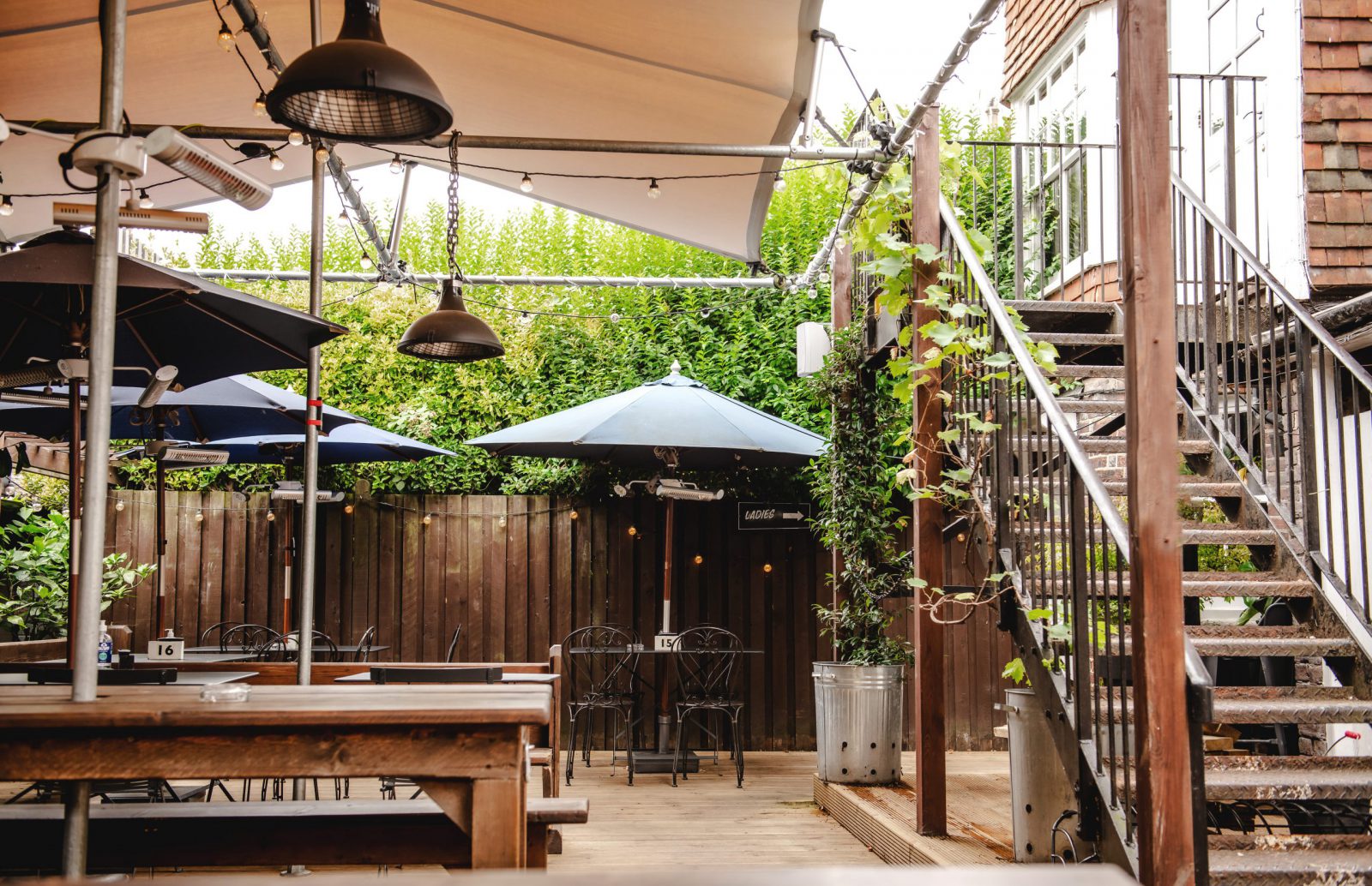 The George pub garden with heaters and large benches covered by an all-weather canopy