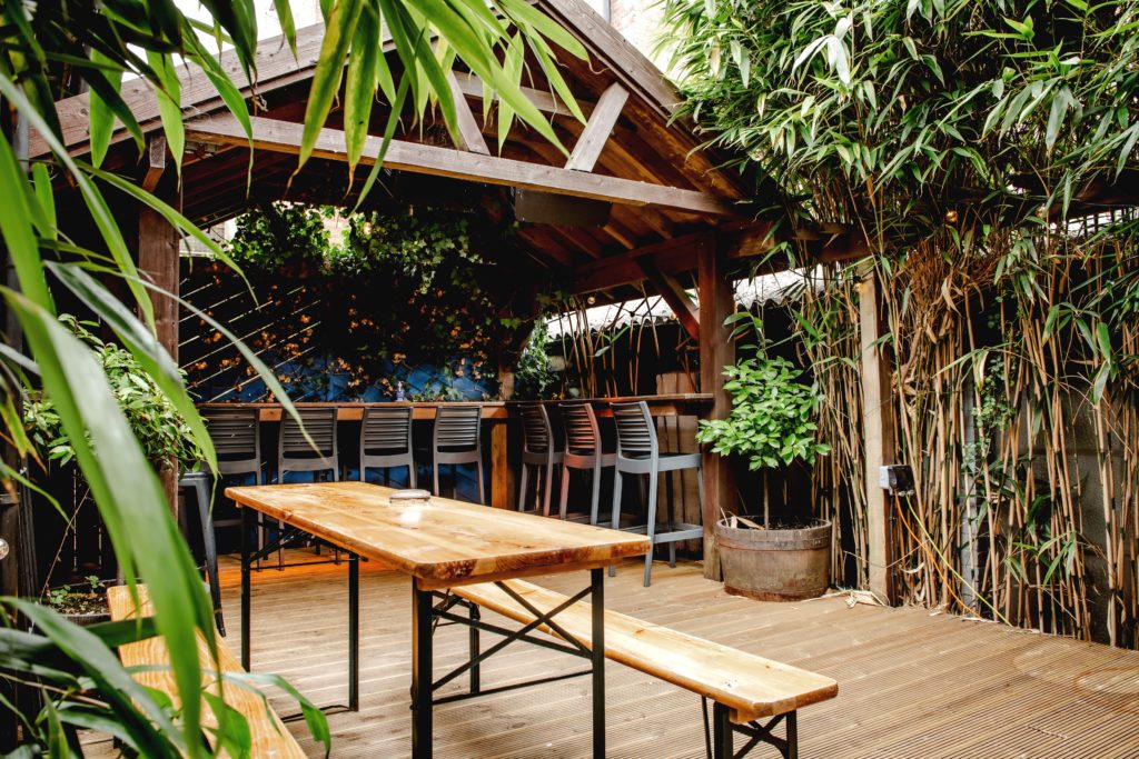 The Geroge pub garden, with plants and timber pergola and outdoor seating