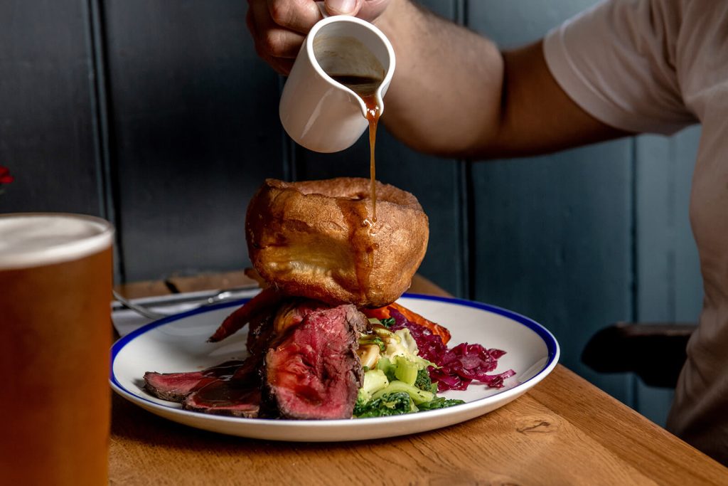 Gravy pouring over yorkshire pudding and sunday roast at the George pub in Tunbridge Wells