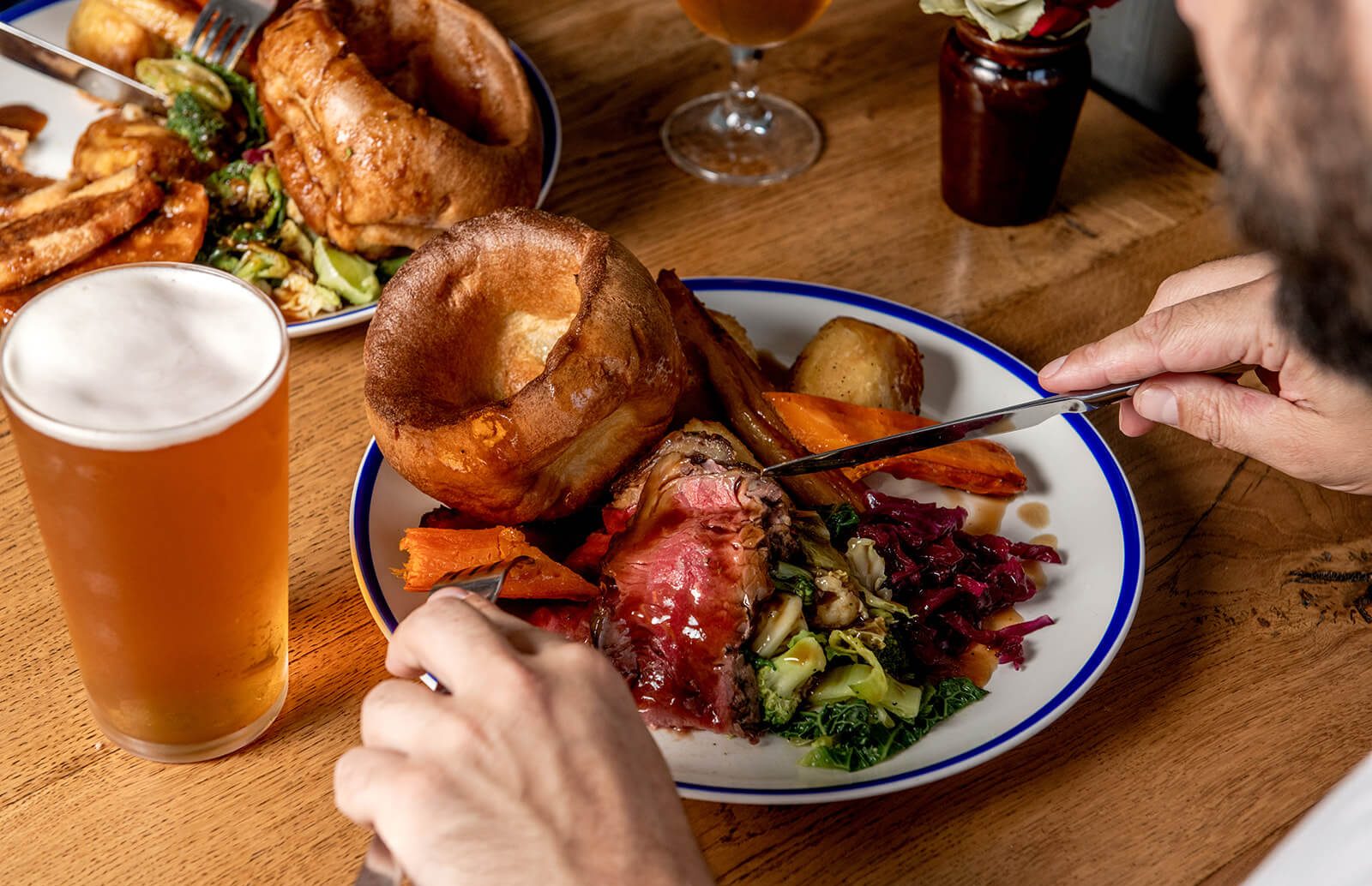 A plate of Sunday Roast with beef, yorkshire pudding, and vegetables