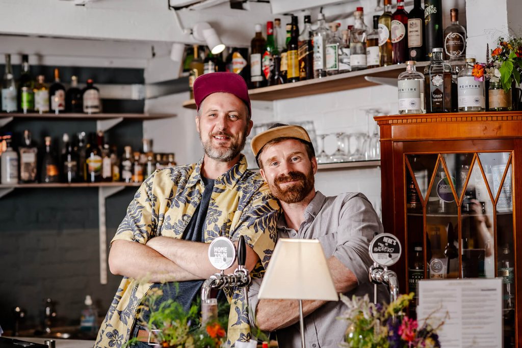 Mixologists, Bob and Ali, stand at their cocktail bar in Tunbridge Wells