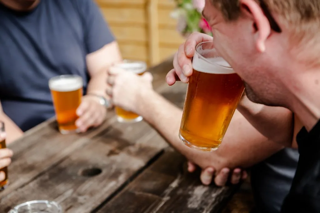A customer in the taproom garden sips his beer